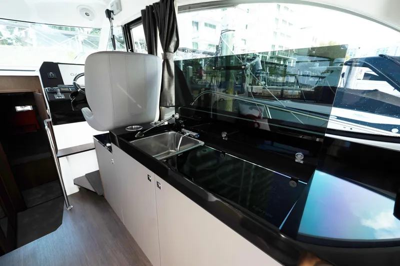 Slide: The Image of Interior of 2022 Beneteau Antares 11 Coupe, featuring sleek kitchen and helm station. - 13