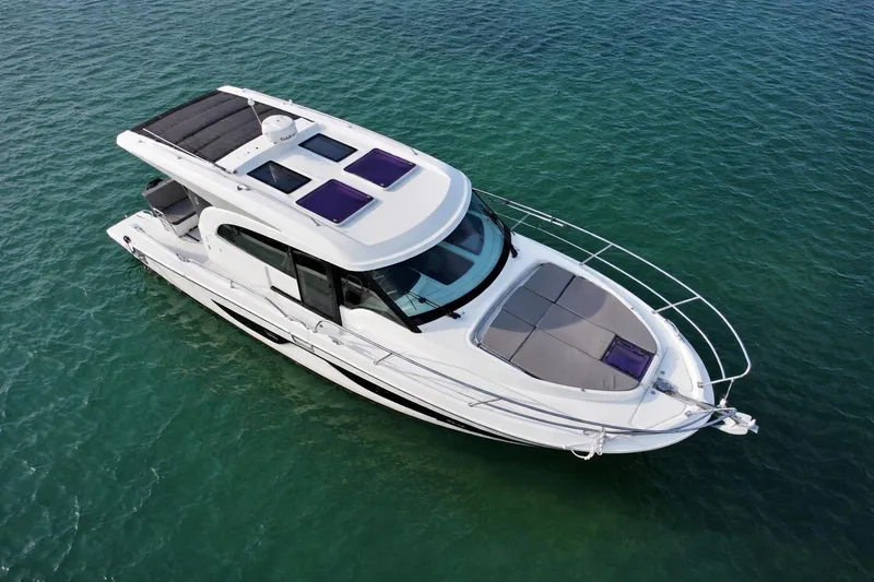 Slide: The Image of 2022 Beneteau Antares 11 Coupe boat on clear blue water, aerial view. - 2