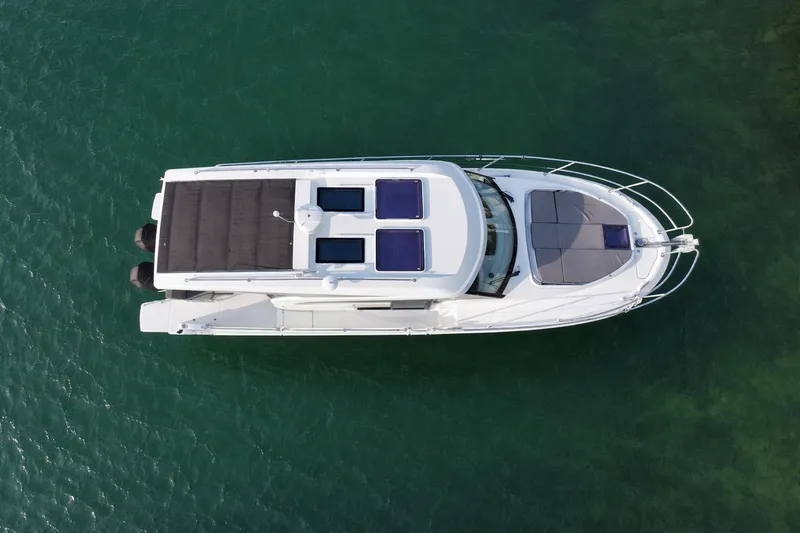 Slide: The Image of Top view of 2022 Beneteau Antares 11 Coupe on clear green water. - 3