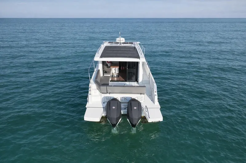 Slide: The Image of 2022 Beneteau Antares 11 Coupe on calm ocean waters, rear view. - 6