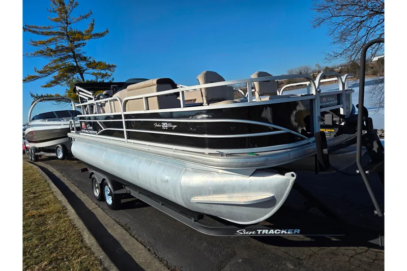 Slide: The Image of 2018 Sun Tracker Fishin' Barge 20 DLX pontoon boat on trailer by a lake. - 10