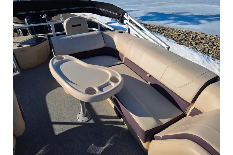 Slide: The Image of 2018 Sun Tracker Fishin' Barge 20 DLX interior with beige seating and table. - 17