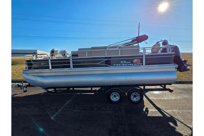 Slide: The Image of 2018 Sun Tracker Fishin' Barge 20 DLX pontoon boat on trailer under bright sun. - 5