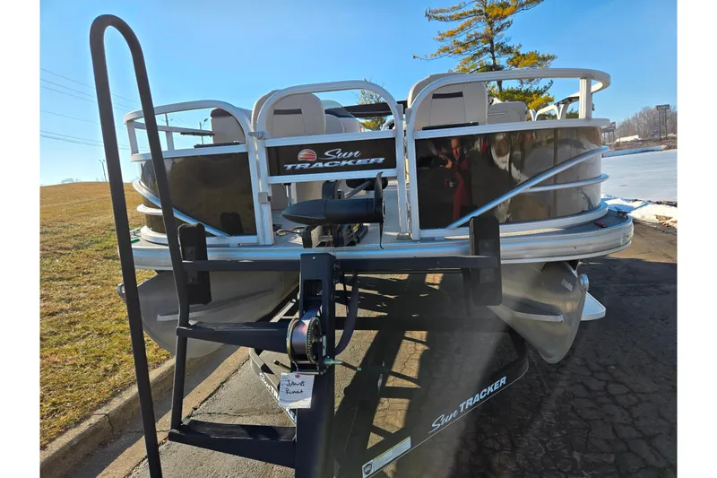 Slide: The Image of 2018 Sun Tracker Fishin' Barge 20 DLX pontoon boat on trailer, parked outdoors. - 8