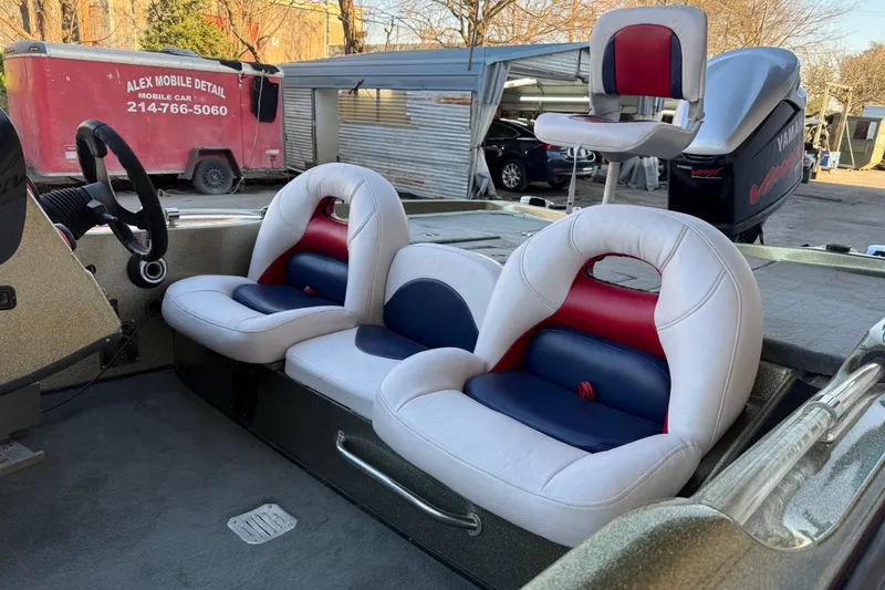 Slide: The Image of 2005 Bass Cat Puma boat interior with white, red, and blue seats, steering wheel, and Yamaha engine. - 17