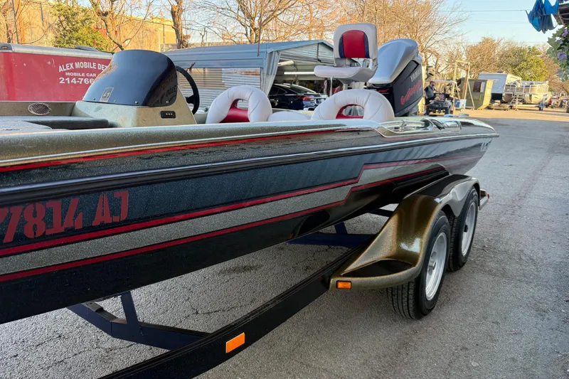 Slide: The Image of 2005 Bass Cat Puma boat on trailer, parked outdoors, featuring sleek design and dual seats. - 18