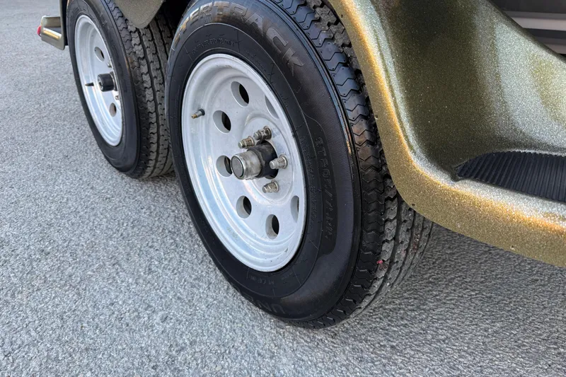 Slide: The Image of 2005 Bass Cat Puma trailer wheels on textured pavement. - 27