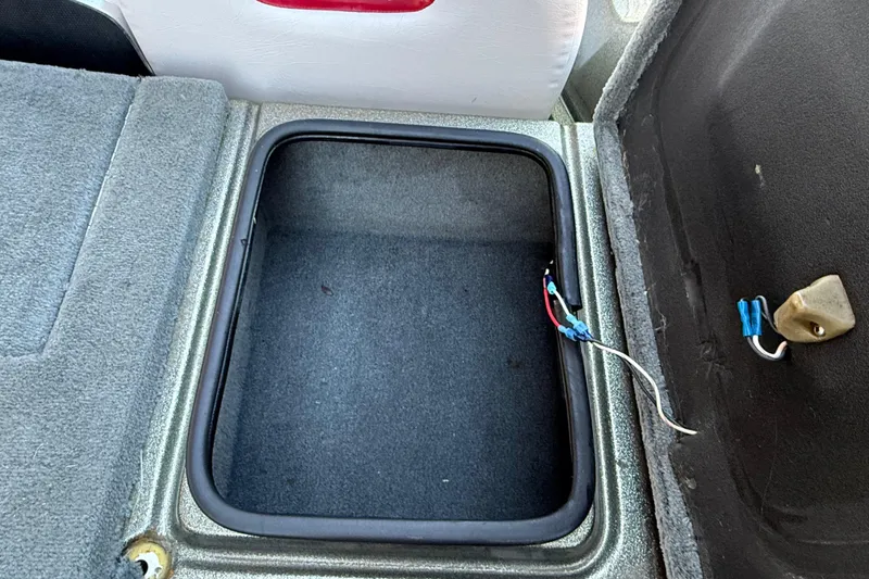 Slide: The Image of Open storage compartment in 2005 Bass Cat Puma boat with visible wiring. - 36