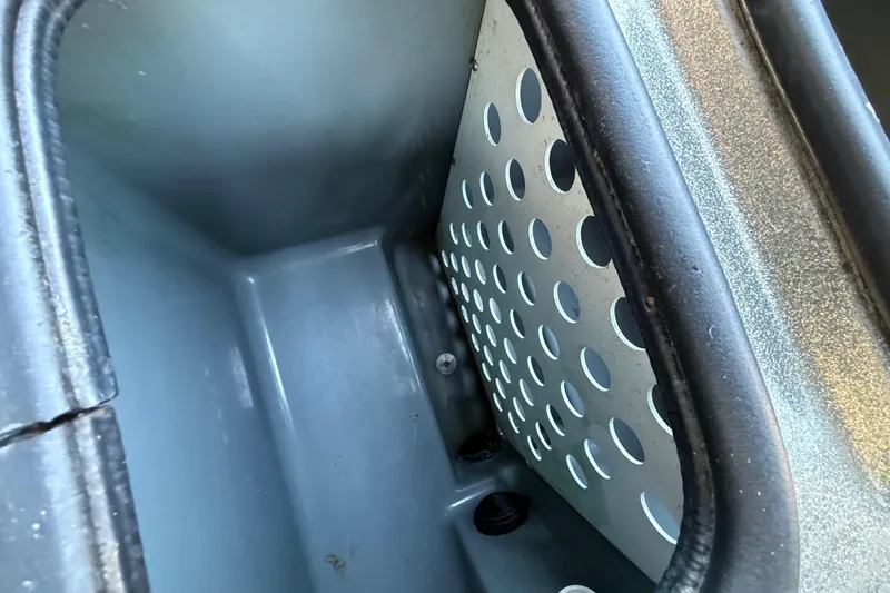 Slide: The Image of Interior compartment of a 2005 Bass Cat Puma boat with perforated metal panel. - 38