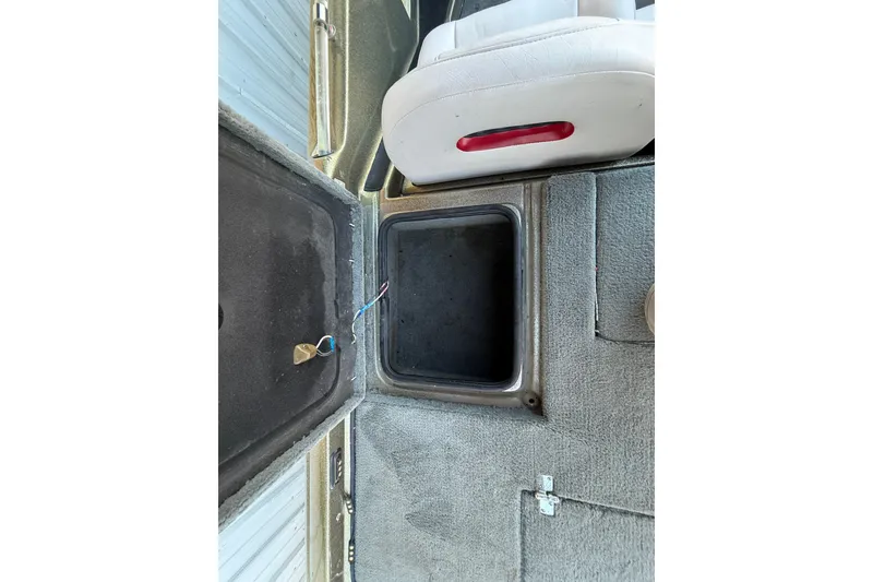 Slide: The Image of 2005 Bass Cat Puma boat interior storage compartment with open lid and visible wiring. - 40