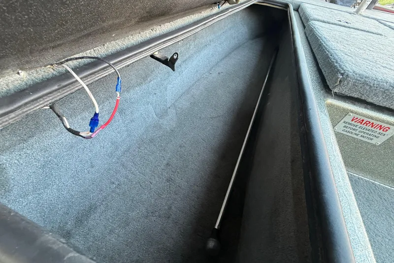 Slide: The Image of 2005 Bass Cat Puma boat storage compartment with wiring and warning label. - 44