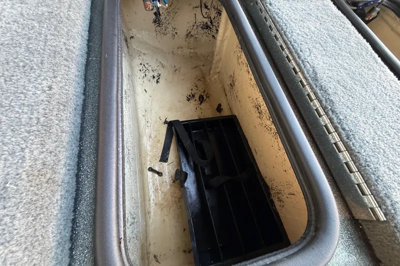 Slide: The Image of 2005 Bass Cat Puma storage compartment with black tray and carpeted edges. - 49