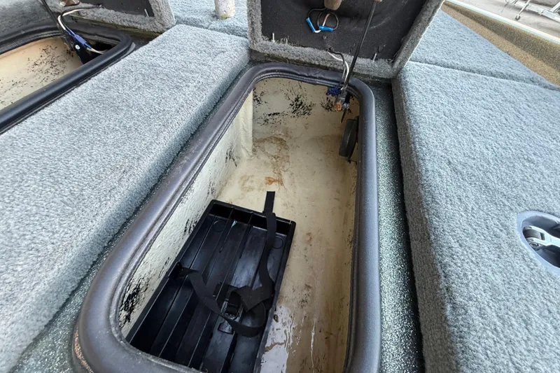 Slide: The Image of 2005 Bass Cat Puma boat storage compartment with carpeted interior and battery holder. - 50