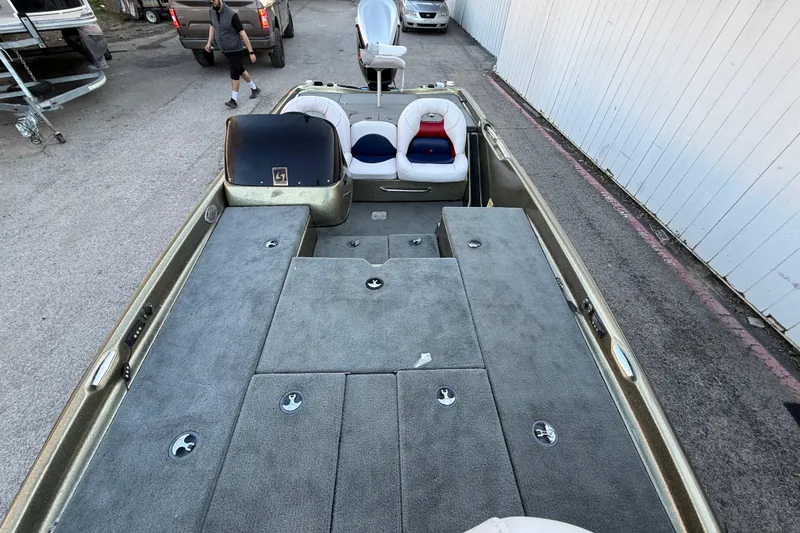 Slide: The Image of 2005 Bass Cat Puma boat with spacious deck and seating, parked outdoors. - 54