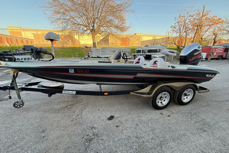 Slide: The Image of 2005 Bass Cat Puma boat on trailer, parked outdoors with Yamaha engine. - 56