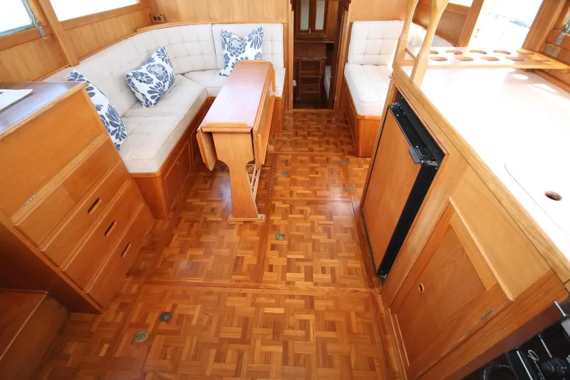 Slide: The Image of 1984 Grand Banks 36 Classic yacht interior with wood flooring and cushioned seating. - 2