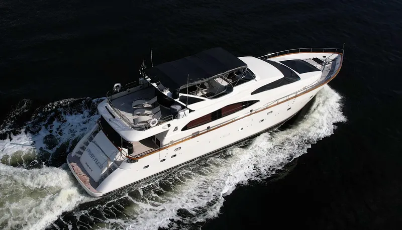 Slide: The Image of 1999 Azimut 85 Ultimate yacht docked near a bridge, rear view. - 102