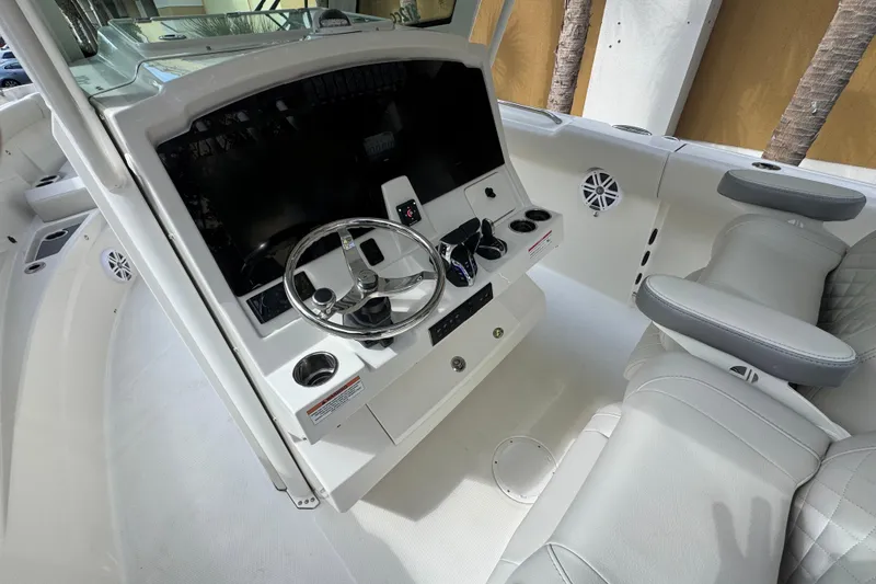 Slide: The Image of 2026 Sailfish 312 CC boat interior with steering wheel and seating. - 11