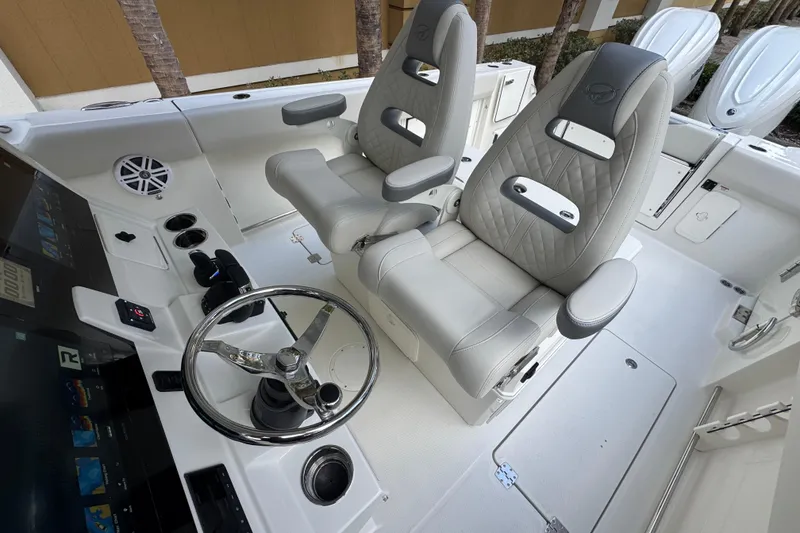 Slide: The Image of 2026 Sailfish 312 CC boat interior with dual captain's chairs and modern steering console. - 13