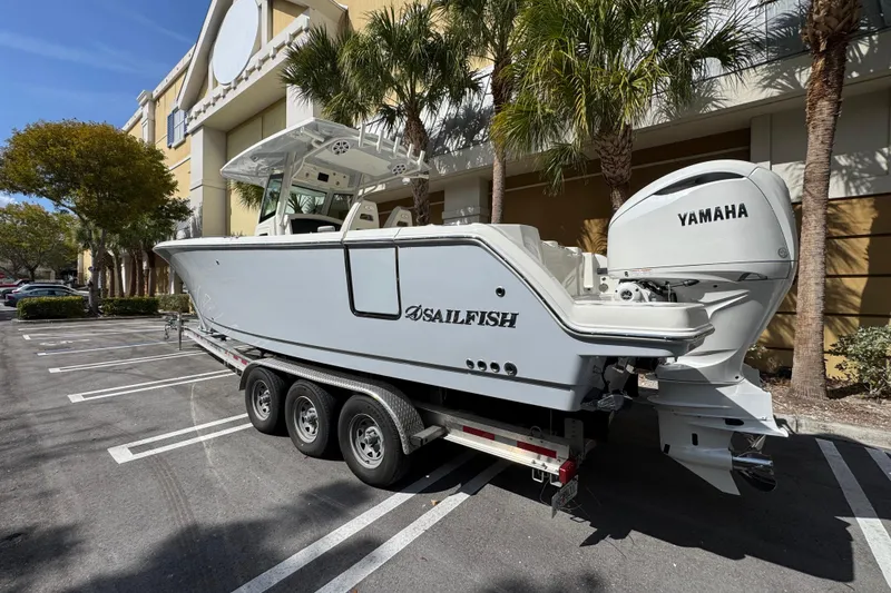 Slide: The Image of 2026 Sailfish 312 CC boat with Yamaha engine on trailer in parking lot. - 2