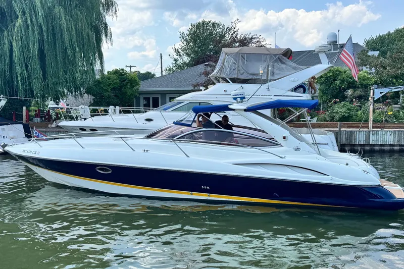 Slide: The Image of 2000 Sunseeker Superhawk 34 yacht docked in a scenic marina setting. - 55