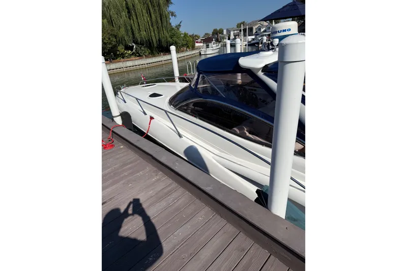 Slide: The Image of Sunseeker Superhawk 34 yacht docked at marina, 2000 model, sleek white design. - 56