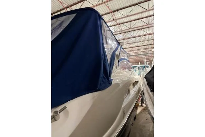 Slide: The Image of Sunseeker Superhawk 34, 2000 model, covered in blue tarp, stored indoors. - 60