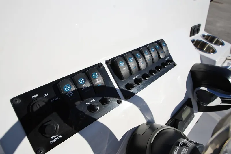 Slide: The Image of Control panel of 2025 Stingray 173 CC boat with switches and cup holders. - 14