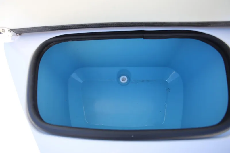 Slide: The Image of Livewell compartment of 2025 Stingray 173 CC boat, featuring a blue interior. - 23