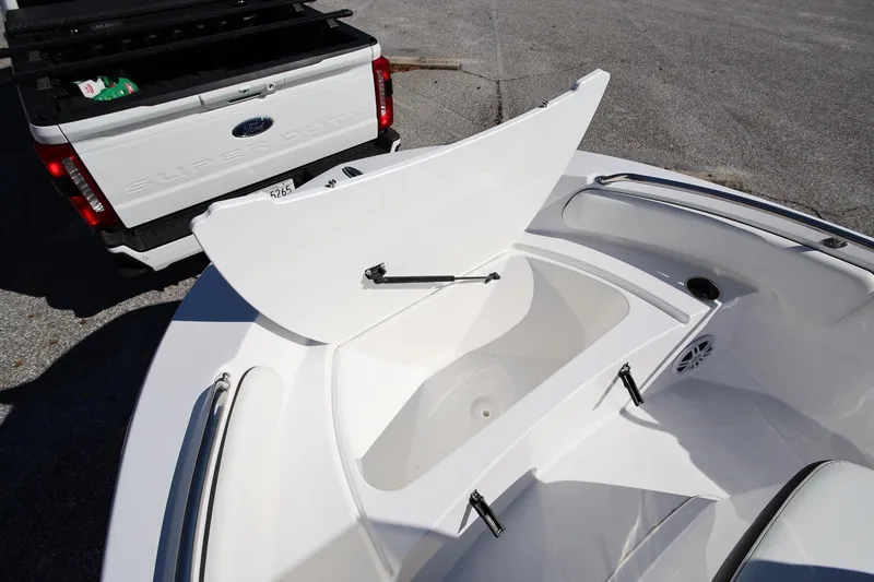 Slide: The Image of 2025 Stingray 173 CC boat with open storage compartment near Ford Super Duty truck. - 24