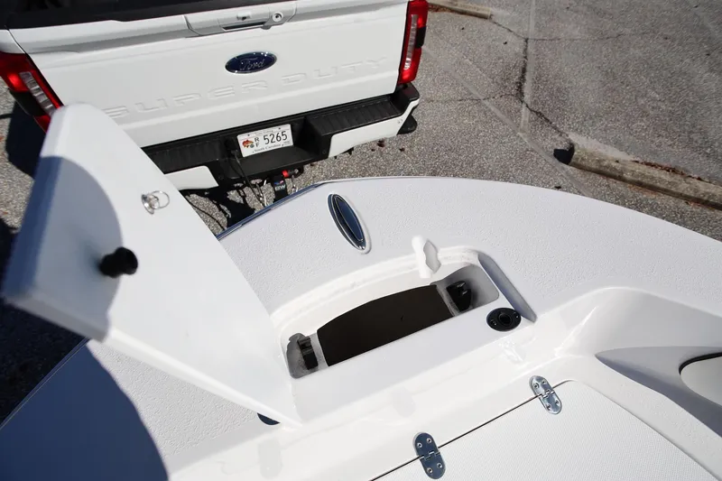 Slide: The Image of 2025 Stingray 173 CC boat with open hatch, parked near a Ford Super Duty truck. - 25