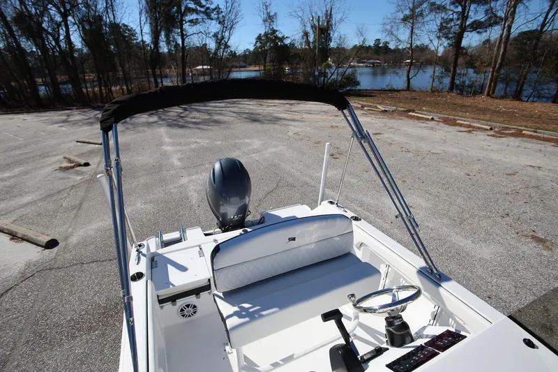 Slide: The Image of 2025 Stingray 173 CC boat with outboard motor, parked near a scenic lake. - 28