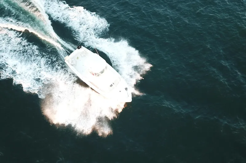 Slide: The Image of Aerial view of 1973 Bertram 31 Flybridge Cruiser speeding on open water. - 10