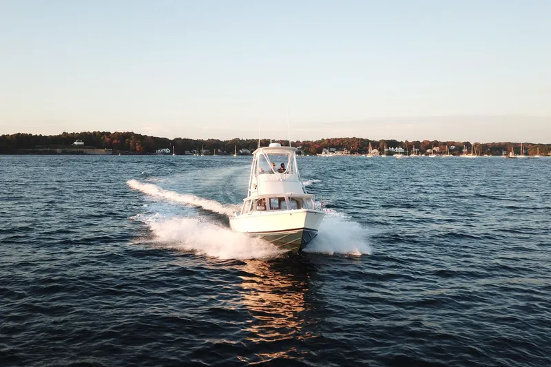 Slide: The Image of 1973 Bertram 31 Flybridge Cruiser speeding on open water at sunset. - 11