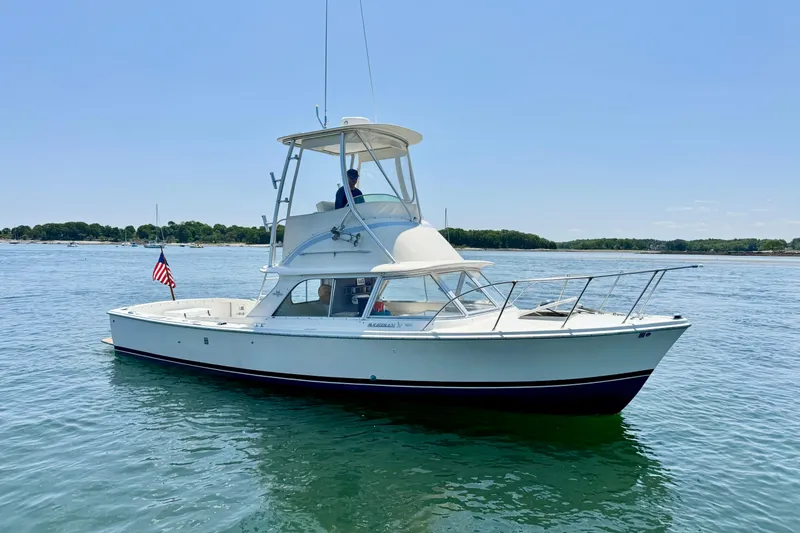 Slide: The Image of 1973 Bertram 31 Flybridge Cruiser on calm water, displaying classic design. - 19