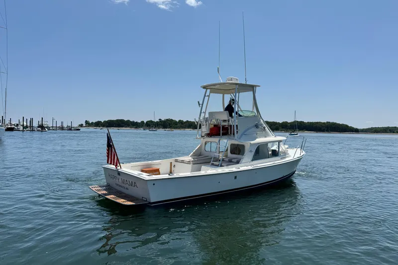 Slide: The Image of 1973 Bertram 31 Flybridge Cruiser on calm water, featuring "Happy Mama" nameplate. - 21