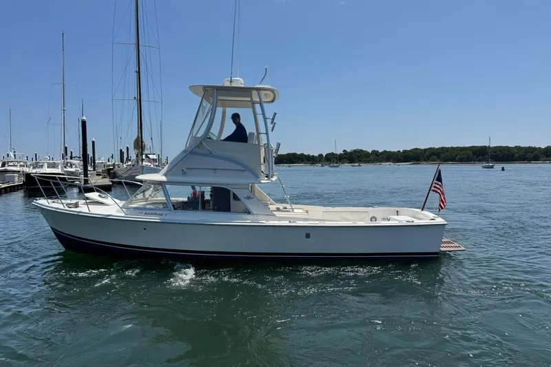 Slide: The Image of 1973 Bertram 31 Flybridge Cruiser on calm water, with American flag, sunny day. - 27