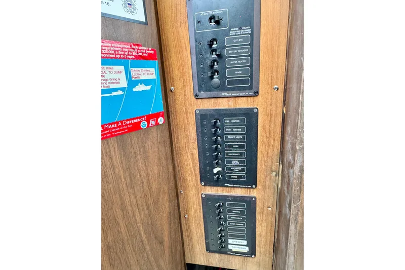 Slide: The Image of 1973 Bertram 31 Flybridge Cruiser control panel with switches and marine safety notice. - 31