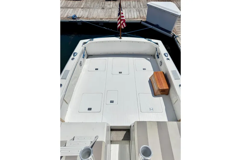 Slide: The Image of 1973 Bertram 31 Flybridge Cruiser deck with American flag and wooden step. - 32