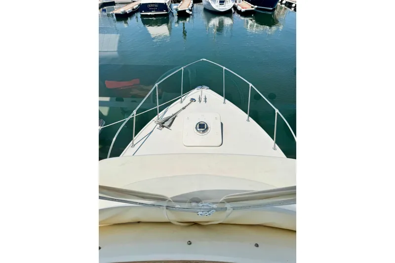 Slide: The Image of 1973 Bertram 31 Flybridge Cruiser bow view at marina, calm water reflections. - 33