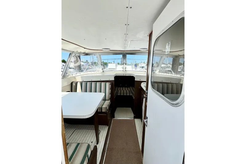 Slide: The Image of Interior of a 1973 Bertram 31 Flybridge Cruiser with striped seating and table. - 5