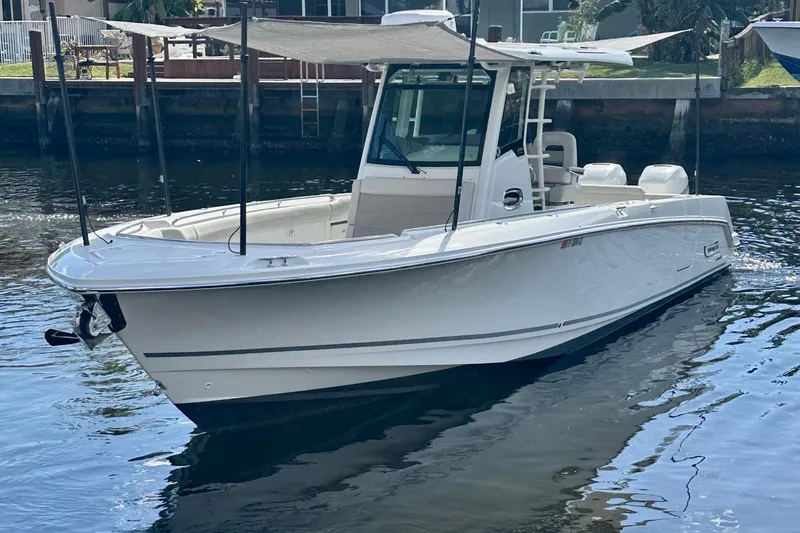 Slide: The Image of 2020 Boston Whaler 330 Outrage boat docked on calm water. - 1