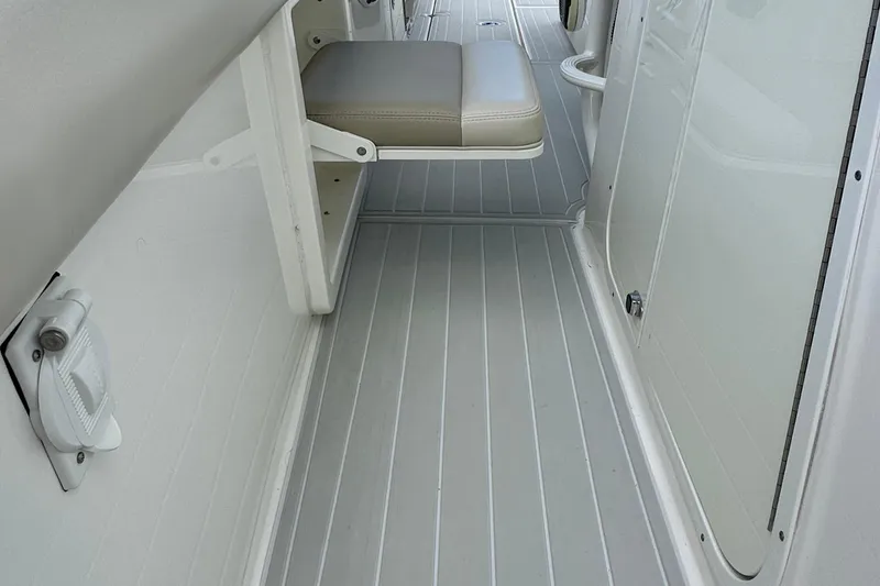 Slide: The Image of 2020 Boston Whaler 330 Outrage interior with foldable seat and sleek flooring. - 11