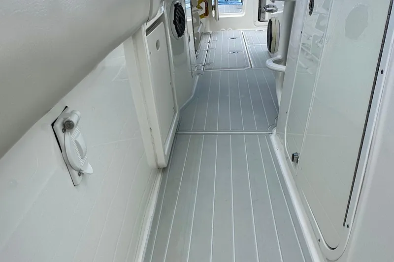 Slide: The Image of 2020 Boston Whaler 330 Outrage interior walkway with sleek, modern design. - 12