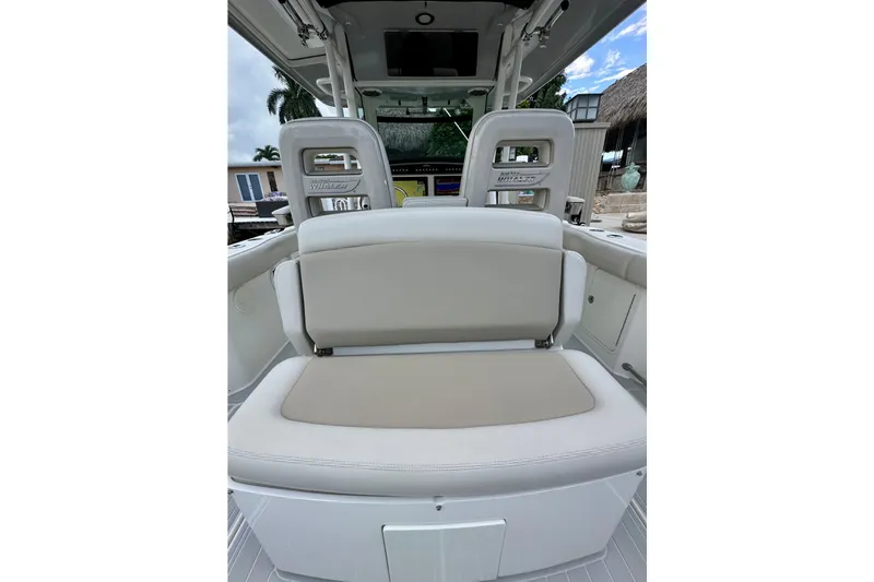 Slide: The Image of 2020 Boston Whaler 330 Outrage boat interior with cushioned seating and helm station. - 13
