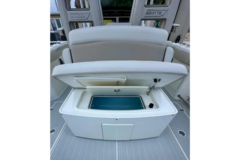 Slide: The Image of 2020 Boston Whaler 330 Outrage boat with open storage compartment and seating. - 14