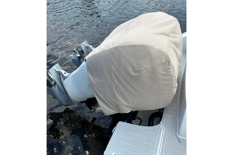 Slide: The Image of 2020 Boston Whaler 330 Outrage with covered outboard motor on water. - 16