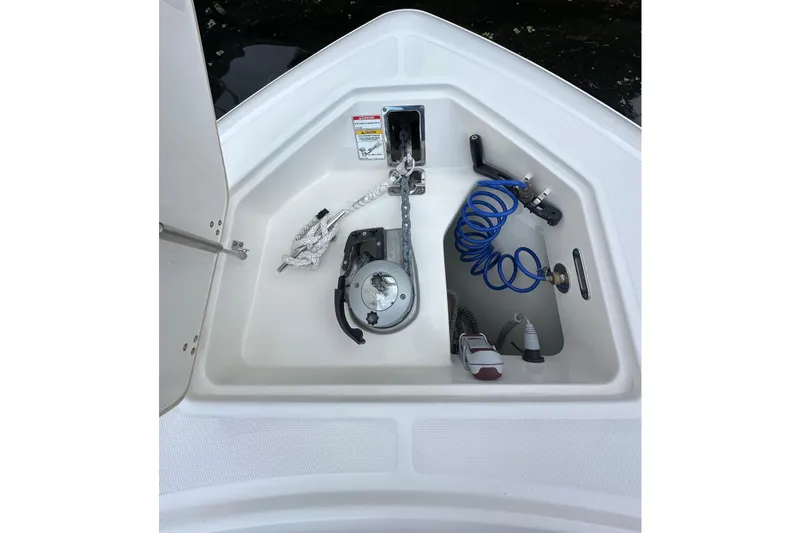 Slide: The Image of Anchor storage compartment on 2020 Boston Whaler 330 Outrage boat, featuring rope and coiled hose. - 18