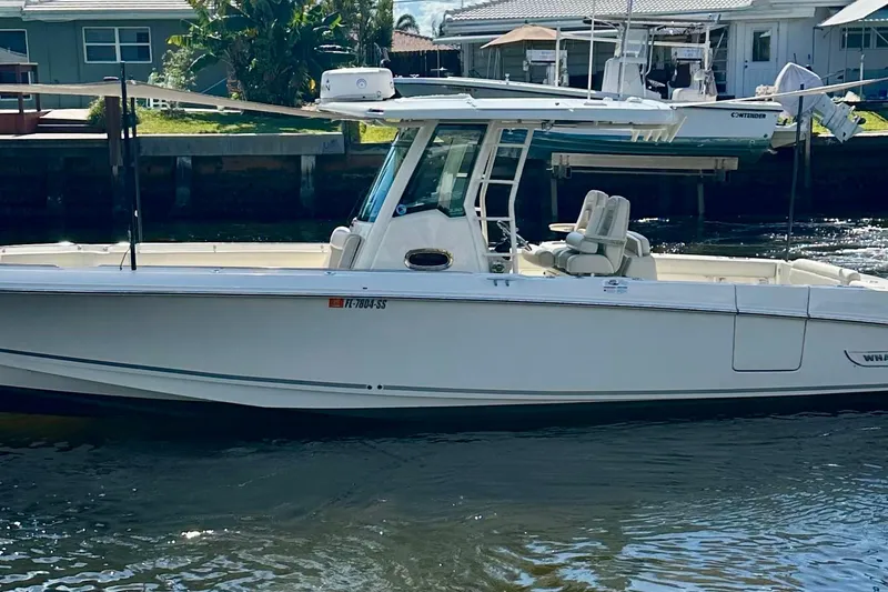 Slide: The Image of 2020 Boston Whaler 330 Outrage boat docked near waterfront homes. - 2