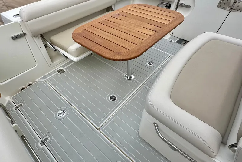 Slide: The Image of 2020 Boston Whaler 330 Outrage interior with wooden table and cushioned seating. - 22